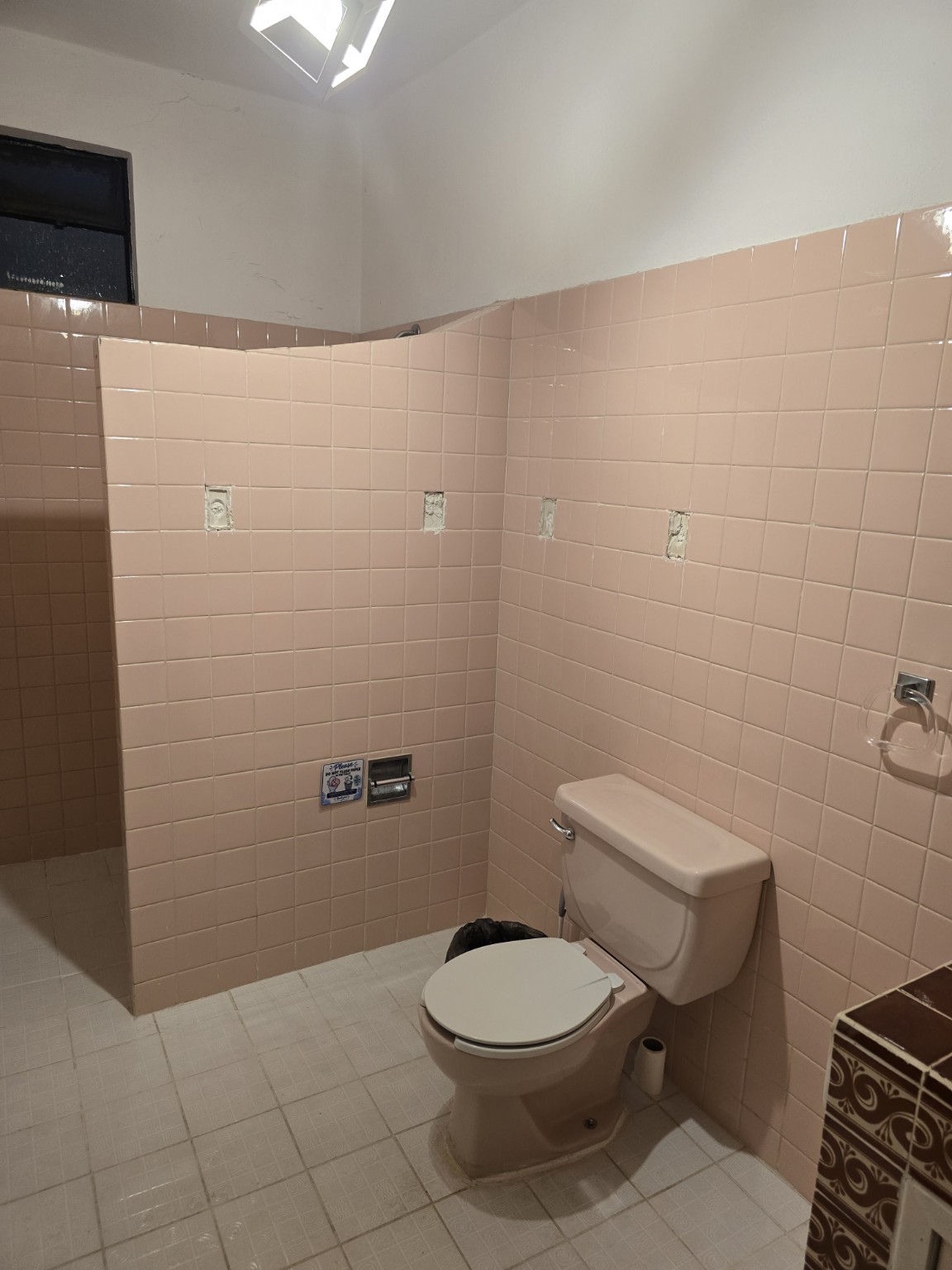 Otra vista del baño con azulejos rosas