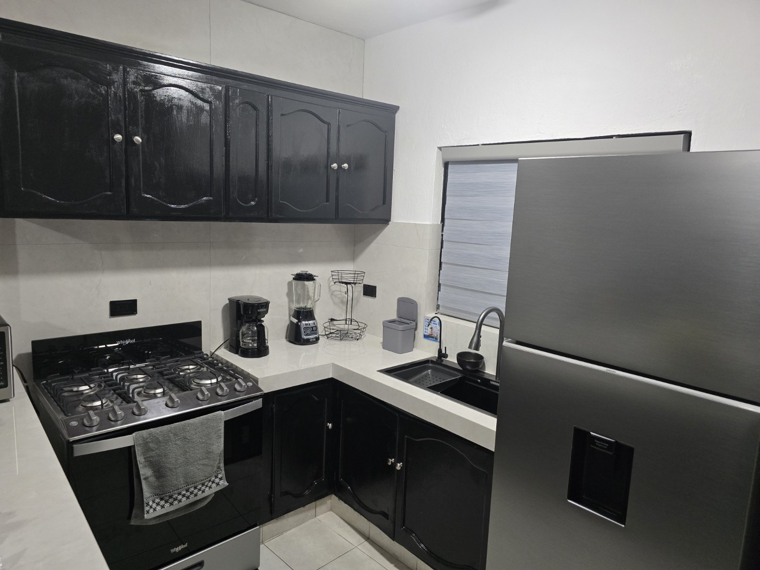 Cocina con refrigerador, estufa y cafetera