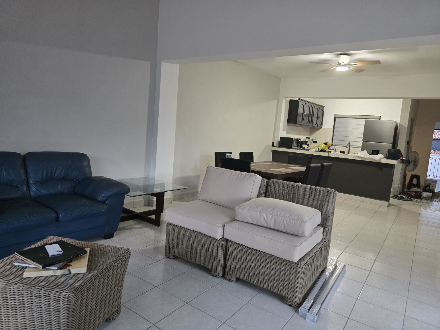 Sala amplia con sillones, comedor y cocina del departamento